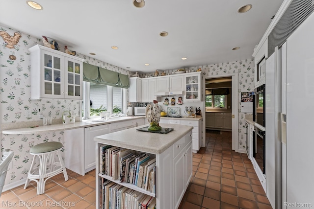 130 Endicott Rd, Bloomfield Hills, MI 48304 - kitchen featuring wallpapered walls, light countertops, white cabinets, healthy amount of natural light, and high end refrigerator