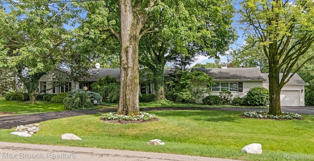 130 Endicott Rd, Bloomfield Hills, MI 48304 - obstructed view of property featuring asphalt driveway, a front lawn, an attached garage, and a chimney