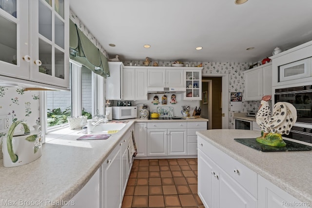 130 Endicott Rd, Bloomfield Hills, MI 48304 - kitchen featuring white microwave, white cabinets, light countertops, wallpapered walls, and extractor fan