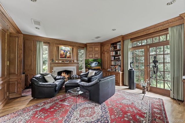 130 Endicott Rd, Bloomfield Hills, MI 48304 - living area featuring a lit fireplace, healthy amount of natural light, light wood finished floors, and wood walls