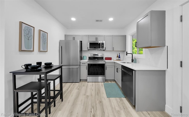 1641 Silman St, Ferndale, MI 48220 - kitchen with appliances with stainless steel finishes, gray cabinets, light wood-style flooring, light countertops, and recessed lighting