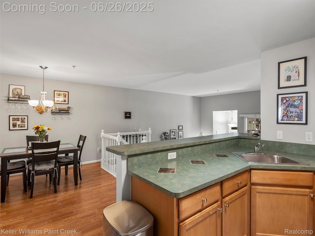 3991 Forester Blvd, Auburn Hills, MI 48326 - kitchen with dark countertops, a chandelier, wood finished floors, pendant lighting, and a peninsula