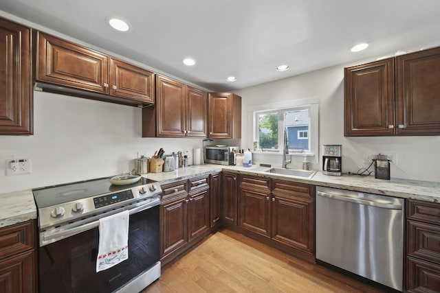 1302 Lansing Ave, Jackson, MI 49202 - kitchen featuring appliances with stainless steel finishes, light wood finished floors, recessed lighting, light stone counters, and dark brown cabinets
