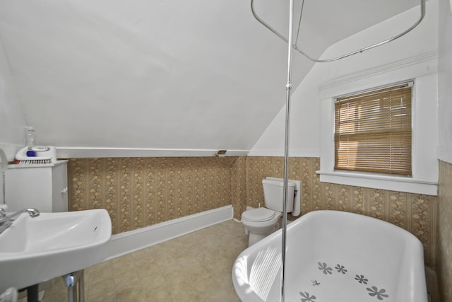 1302 Lansing Ave, Jackson, MI 49202 - bathroom featuring a freestanding tub, lofted ceiling, and wallpapered walls