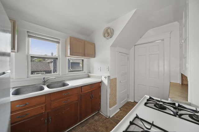 1302 Lansing Ave, Jackson, MI 49202 - kitchen featuring light countertops, lofted ceiling, stovetop, and freestanding refrigerator