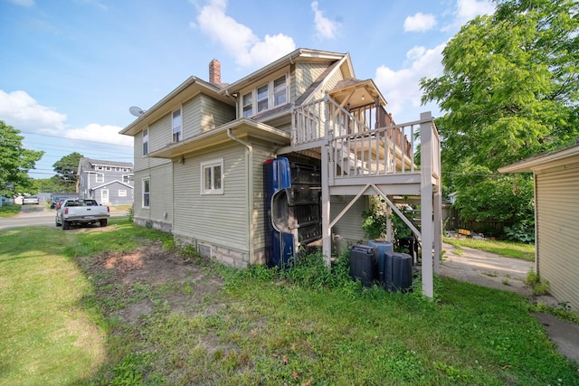 1302 Lansing Ave, Jackson, MI 49202 - back of house with a chimney, stairway, a wooden deck, and a yard