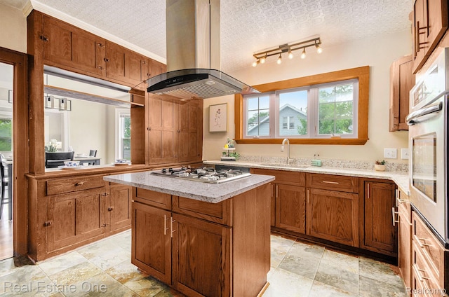 22500 Boulder Ave, Eastpointe, MI 48021 - kitchen with island range hood, gas stovetop, a center island, oven, and brown cabinetry