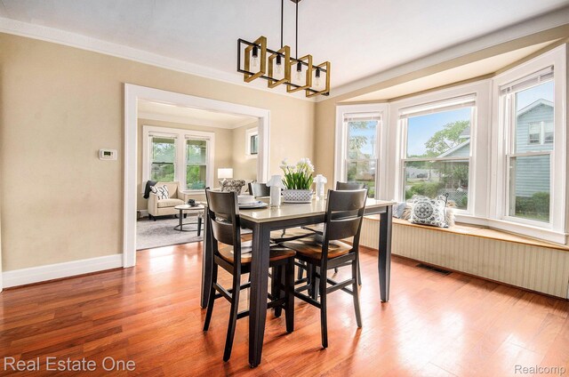 22500 Boulder Ave, Eastpointe, MI 48021 - dining area featuring light wood-style flooring, a chandelier, and crown molding