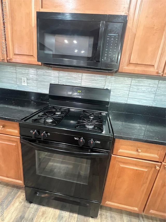 4064 Moore St, Inkster, MI 48141 - kitchen with black appliances, dark countertops, tasteful backsplash, and light wood-type flooring