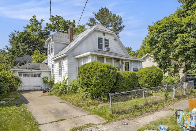 103 Webber St, Battle Creek, MI 49015 - view of front of house featuring a chimney, a garage, concrete driveway, an outbuilding, and a shingled roof