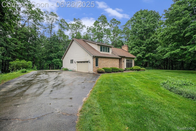 6375 Perryville Rd, Holly, MI 48442 - view of front of house with asphalt driveway, a chimney, a front lawn, brick siding, and a garage