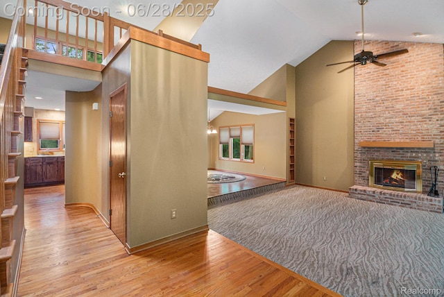 6375 Perryville Rd, Holly, MI 48442 - unfurnished living room with high vaulted ceiling, wood finished floors, ceiling fan, and a fireplace