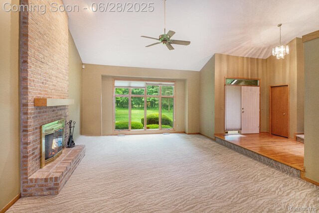 6375 Perryville Rd, Holly, MI 48442 - unfurnished living room featuring carpet floors, high vaulted ceiling, ceiling fan, a brick fireplace, and a chandelier
