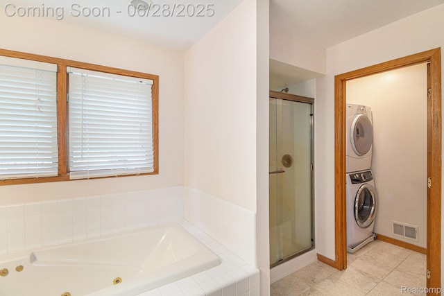 6375 Perryville Rd, Holly, MI 48442 - bathroom with stacked washer / dryer, a stall shower, a tub with jets, and tile patterned flooring