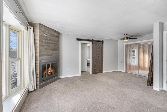9922 S Sprinkle Rd, Portage, MI 49002 - unfurnished living room with a barn door, plenty of natural light, carpet flooring, and ceiling fan