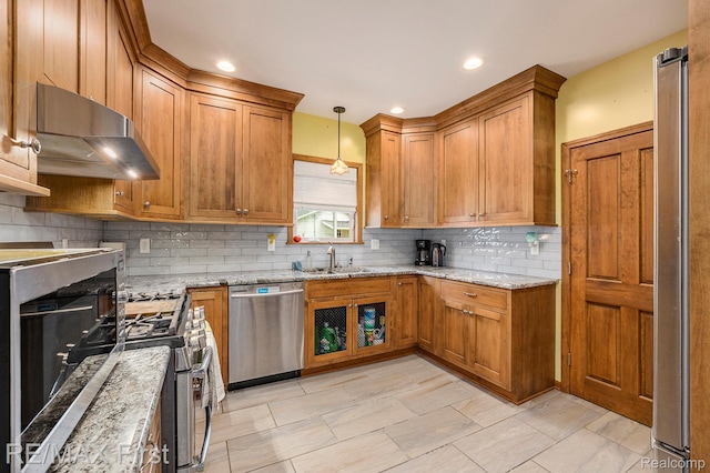 442 Washington St, Marine City, MI 48039 - kitchen with appliances with stainless steel finishes, extractor fan, brown cabinets, decorative backsplash, and light stone countertops