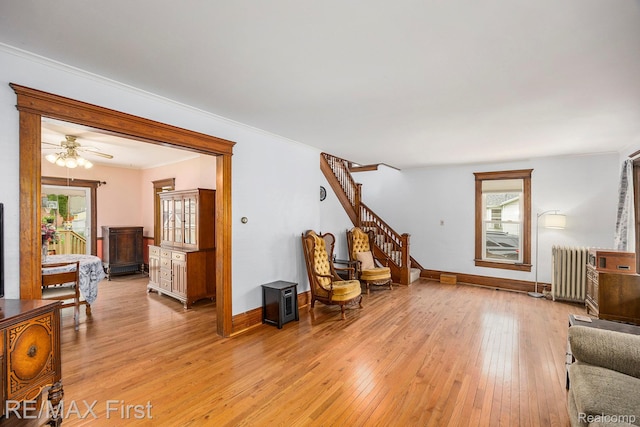 442 Washington St, Marine City, MI 48039 - living room featuring radiator heating unit, healthy amount of natural light, light wood finished floors, stairs, and crown molding