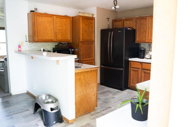 181 Spring St, Hillsdale, MI 49242 - kitchen with black appliances, a peninsula, light countertops, and tasteful backsplash
