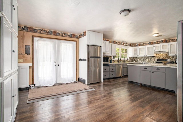 11303 W Dr N, Bellevue, MI 49021 - kitchen with appliances with stainless steel finishes, gray cabinets, light countertops, under cabinet range hood, and dark wood-style floors