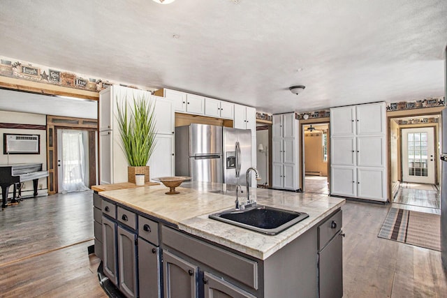 11303 W Dr N, Bellevue, MI 49021 - kitchen featuring stainless steel fridge with ice dispenser, gray cabinets, a spacious island, dark wood-style flooring, and light countertops
