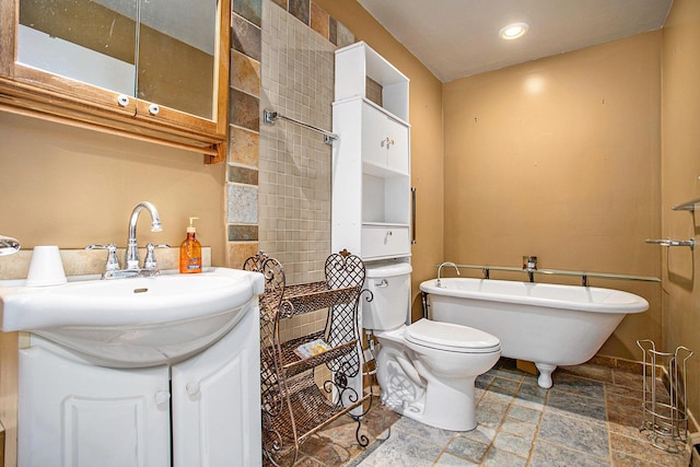 11303 W Dr N, Bellevue, MI 49021 - full bathroom featuring stone tile floors, a freestanding tub, vanity, and recessed lighting