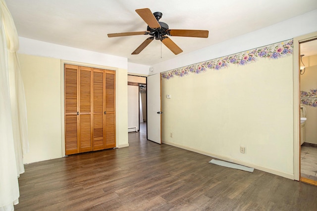 11303 W Dr N, Bellevue, MI 49021 - unfurnished bedroom featuring wood finished floors, a baseboard radiator, ceiling fan, ensuite bath, and a closet