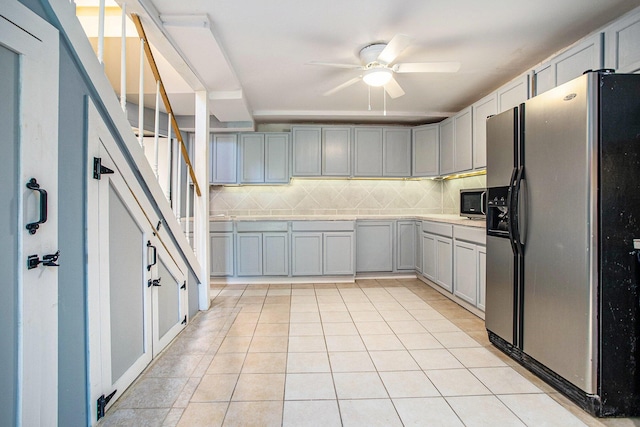 11303 W Dr N, Bellevue, MI 49021 - kitchen featuring stainless steel fridge, a ceiling fan, gray cabinetry, decorative backsplash, and light tile patterned floors