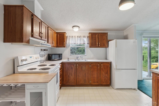 4150 Buzzell Rd, Gladwin, MI 48624 - kitchen with white appliances, light countertops, a textured ceiling, brown cabinets, and light floors