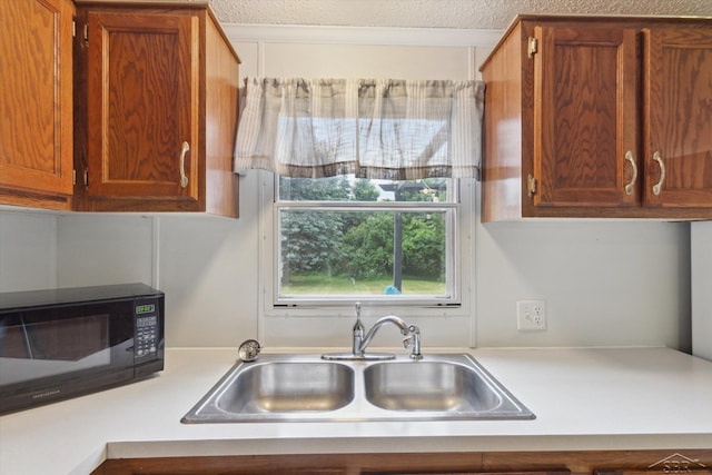 4150 Buzzell Rd, Gladwin, MI 48624 - kitchen with light countertops, brown cabinets, and a textured ceiling