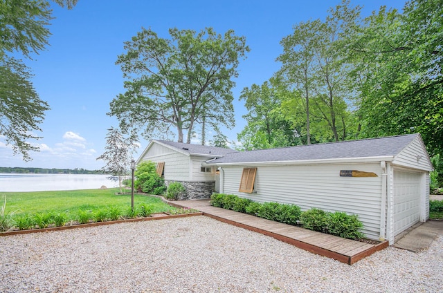 4449 Cordley Lake Rd, Pinckney, MI 48169 - view of front facade featuring a water view, a front yard, a garage, and a shingled roof