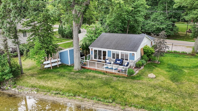 4449 Cordley Lake Rd, Pinckney, MI 48169 - rear view of house with a shingled roof, a shed, a yard, and a deck with water view