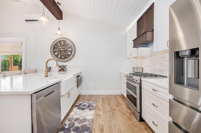 4449 Cordley Lake Rd, Pinckney, MI 48169 - kitchen featuring appliances with stainless steel finishes, ventilation hood, a peninsula, backsplash, and light countertops