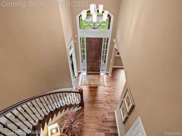 3551 Royal Berkshire Ln, Oakland, MI 48363 - foyer entrance with a towering ceiling, stairway, wood finished floors, and a chandelier
