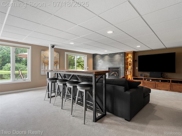 3551 Royal Berkshire Ln, Oakland, MI 48363 - cinema room with light carpet, a drop ceiling, plenty of natural light, a glass covered fireplace, and recessed lighting