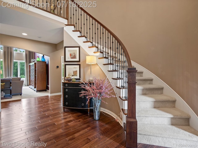 3551 Royal Berkshire Ln, Oakland, MI 48363 - stairs featuring wood finished floors, a towering ceiling, and recessed lighting
