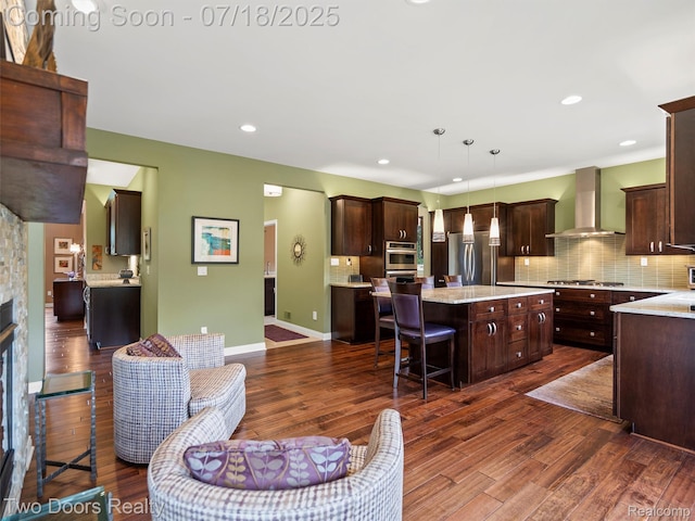 3551 Royal Berkshire Ln, Oakland, MI 48363 - kitchen with a center island, dark brown cabinets, wall chimney exhaust hood, decorative backsplash, and recessed lighting