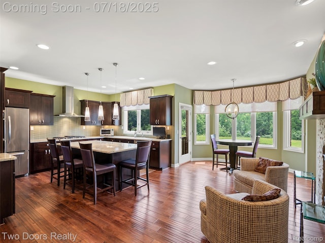 3551 Royal Berkshire Ln, Oakland, MI 48363 - kitchen with a kitchen island, dark brown cabinets, freestanding refrigerator, tasteful backsplash, and a kitchen breakfast bar