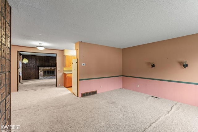 5232 Maple Ave, Swartz Creek, MI 48473 - empty room featuring a fireplace, carpet floors, and a textured ceiling
