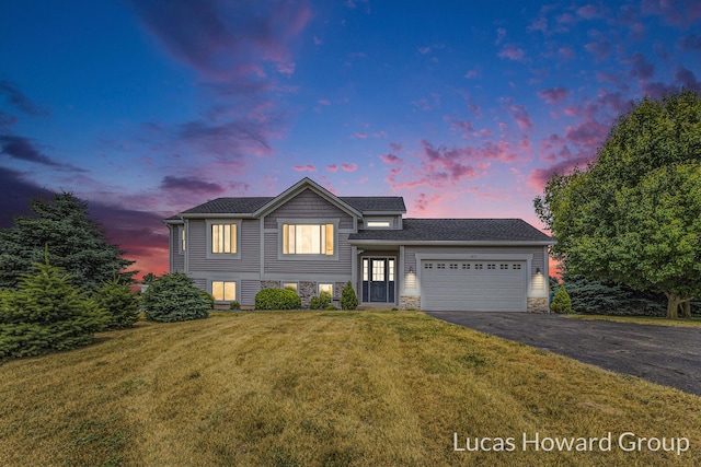 3475 Lone Oak Ln, Dorr, MI 49323 - view of front of house featuring asphalt driveway, an attached garage, a lawn, and stone siding