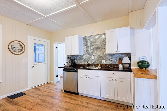 2550 Crozier Ave, Muskegon, MI 49441 - kitchen with dishwasher, tasteful backsplash, white cabinetry, light wood-type flooring, and wooden walls