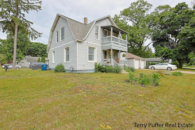 2550 Crozier Ave, Muskegon, MI 49441 - view of side of home with a balcony, a gambrel roof, a lawn, and a garage