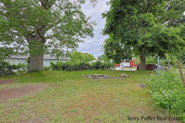 2550 Crozier Ave, Muskegon, MI 49441 - view of grassy yard with an outdoor fire pit