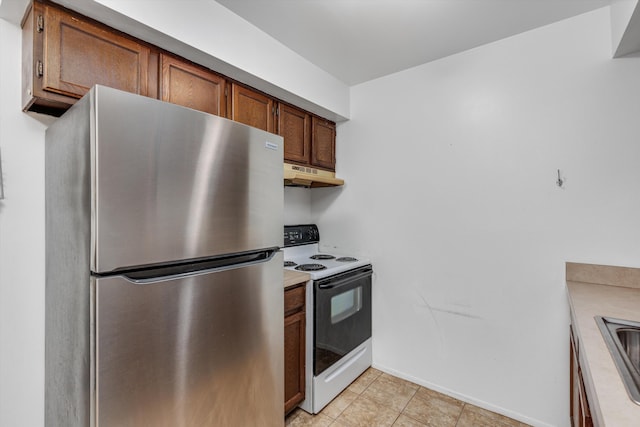 22811 Grove St, Saint Clair Shores, MI 48080 - kitchen with freestanding refrigerator, white electric stove, under cabinet range hood, light countertops, and brown cabinets