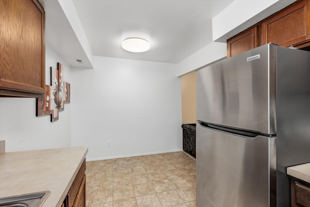 22811 Grove St, Saint Clair Shores, MI 48080 - kitchen featuring freestanding refrigerator, light countertops, and brown cabinetry