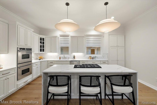 855 Wallace St, Birmingham, MI 48009 - kitchen with stainless steel appliances, a breakfast bar, white cabinets, a center island, and crown molding