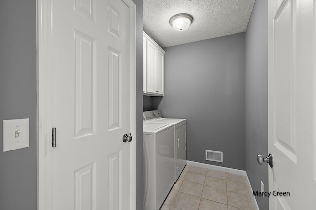 5589 Sandalwood Ct Unit 22, Norton Shores, MI 49441 - laundry room featuring separate washer and dryer, cabinet space, light tile patterned floors, and a textured ceiling