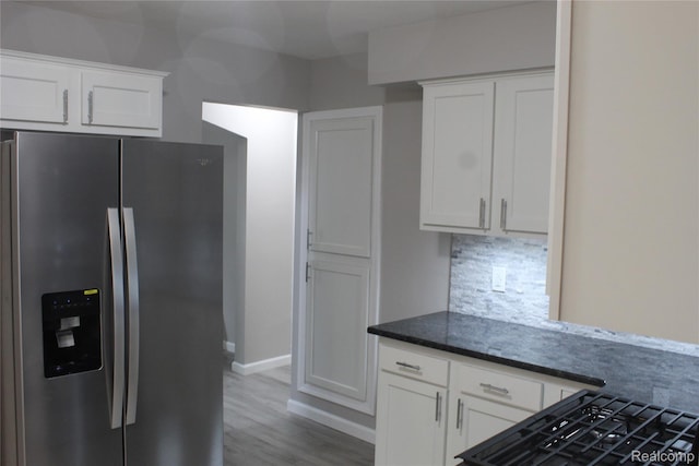 20153 Hartwell St, Detroit, MI 48235 - kitchen featuring stainless steel fridge, white cabinets, backsplash, and dark stone countertops