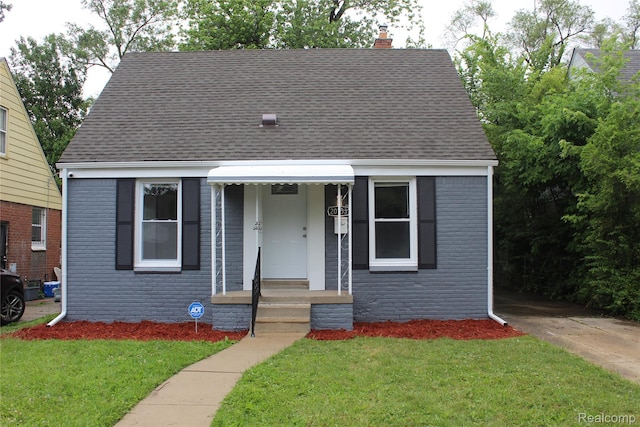 20153 Hartwell St, Detroit, MI 48235 - bungalow-style home featuring a chimney, roof with shingles, brick siding, and a front yard