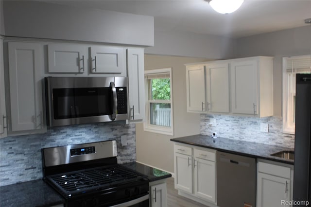20153 Hartwell St, Detroit, MI 48235 - kitchen with appliances with stainless steel finishes, decorative backsplash, white cabinetry, and dark stone countertops