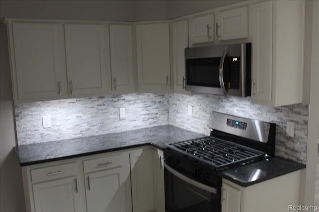 20153 Hartwell St, Detroit, MI 48235 - kitchen featuring appliances with stainless steel finishes, white cabinets, backsplash, and dark countertops